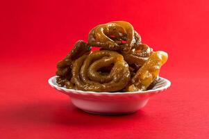 Indian sweet jalebi, indian dessert jalebi or imarti or imarati or jilbi on red background photo