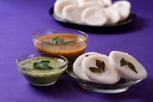 A bowl of rice with a small bowl of sauce and a small bowl of dumplings photo