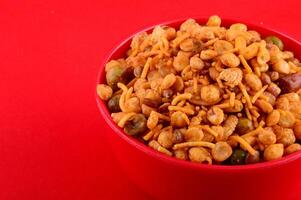 A bowl of mixed nuts and beans on a red surface photo