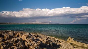 A view of the ocean and rocky shoreline with clouds in the sky video