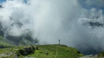 A cross on a mountain with clouds in the background video