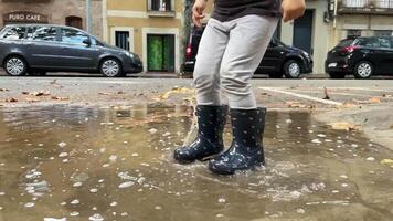 A child in rain boots jumping in puddle video