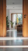 Opened wooden door leads to bright room, sofa set, modern decor, blurred background elements, natural light, clean and empty feel photo