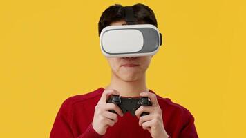 Asian guy wearing virtual reality goggles holds a game controller while engaging in an immersive gaming experience against a bright yellow background. video