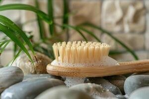 Natural bath brush with soap foam resting on stones in a spa setting photo