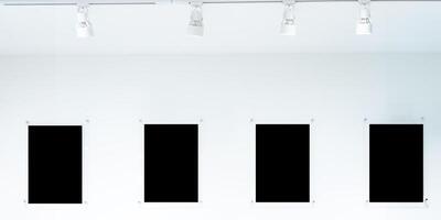 A row of black frames hang from a white wall. The frames are all different sizes and shapes, clipping path. photo