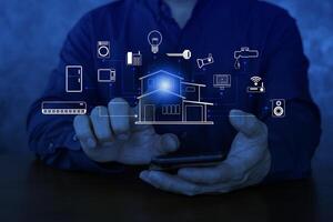 Hand using smartphone as smart home control application, smart home concept banner. glowing house humid with diverse icons, interface and binary. photo
