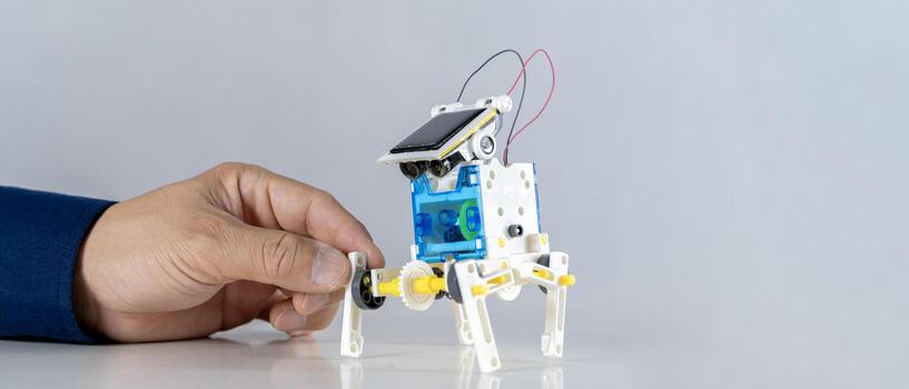 Man inventing building robots learning cars together in STEM class. Happy students, children learning together building robots in classroom. photo