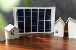 On desk of engineers lay model of house And solar panels to use in planning installation of solar panels to house. photo