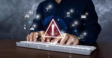 Businessman using computer laptop with triangle caution warning sign for notification error and maintenance concept. photo