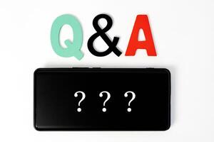 Questions and Answers Q A session concept with hands holding modern tablet or smartphone. photo