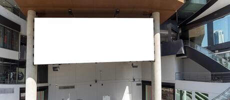 The billboard is empty and could be used to display advertisements or other information. The building is made of glass and steel and has a modern design in a busy city street. photo