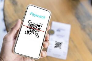 Male hand holding a smartphone with qr code on the screen. scanning the qr code. Barcode reader. Cashless technology. photo
