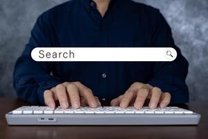 The user is typing a keyboard with a hologram search box. Searching information on the Internet, cloud information online can search. photo