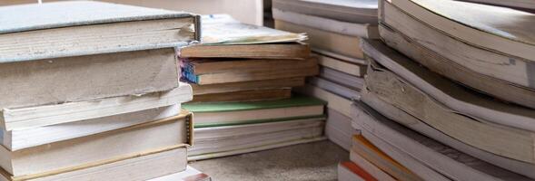 A stack of books in a variety of colors and sizes with different covers and titles. A collection of books in a bookstore. photo