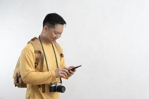 Happy traveler in summer dress using smartphone typing sms message making winner gesture isolated on gray background. photo