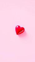 single red heart on a pink background photo