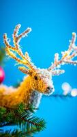 white frosted reindeer ornament with golden lights on a pine branch photo