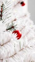 red ornament on a white artificial pine tree branch photo