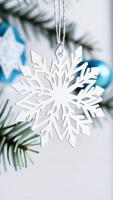 white paper snowflake ornament hangs from a string photo