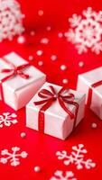 white gift boxes with red ribbons snowflake decorations on a red surface photo