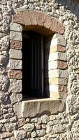 weathered stone wall with a partially open window photo