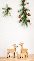 family wooden deer figurines decorated with evergreen branches photo
