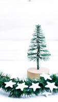 miniature snowy evergreen tree with star ornaments photo