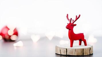 red wooden reindeer figurine stands on a wood slice photo