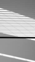 sunlight casting horizontal shadows on a white wall photo