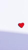 single red heart on a white textured background photo