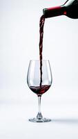 bottle red wine being poured into a crystal goblet photo