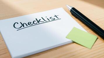 checklist notepad with a green sticky note a pen photo