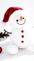 cheerful plush snowman wearing a red knit hat photo