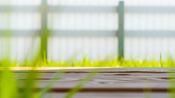 wooden surface with a blurred background a fence grass photo