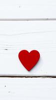 red heart on a white wooden surface photo