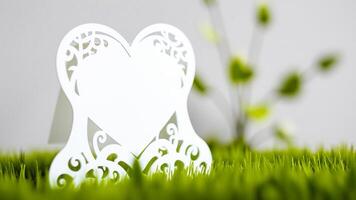 white heart-shaped card with intricate cutouts grass photo