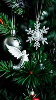 white angel ornament on a green tree branch photo
