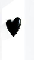black heart-shaped object on a white surface photo