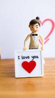 plastic figure holding a 'i love ' message photo