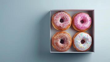 Box with four donuts with colorful icing photo