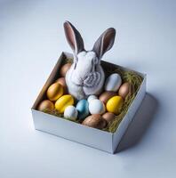 A white rabbit is sitting in a box with eggs photo