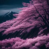 A beautiful pink tree stands in front of a mountain photo