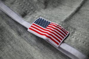 Embroidered American flag on grey fabric. USA flag on grey fabric background. photo