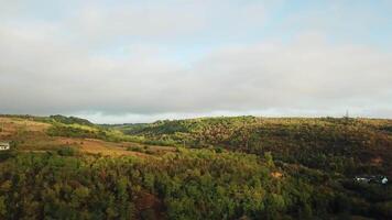 Beautiful landscape of rural place with brown meadows and fields. Panorama of natural environment with hills and forests under the sky. Slow motion of camera video