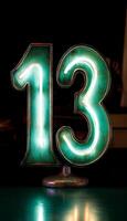 Glowing Neon Number 13 on Dark Surface, Minimalistic Design, Concept of Fear, Superstition photo