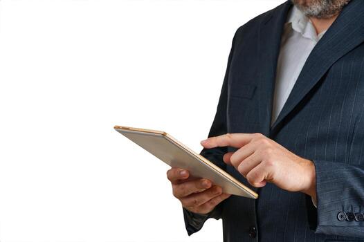 A businessman dressed in a formal suit is actively using a tablet device. The background features a solid color, highlighting his professional demeanor and focus on technology. photo