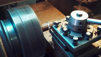 A detail is cutting with using a rotating lathe producing remnants of metal shavings in the plant. Close-up. video