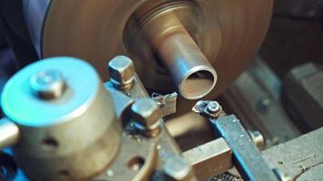 A metal shavings are falling to the floor during processing of part on the lathe in the production. Close-up. video