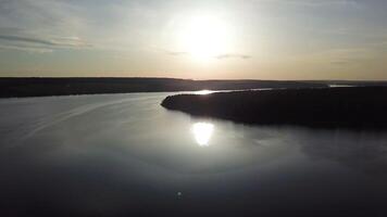 Magnificent view of the river with the reflection of the sun in it from aerial view. Camera motion to back. Sunrise. video
